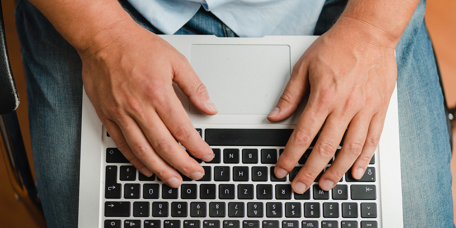 Person arbeitet auf einem Laptop zur Kontaktaufnahme mit einer Praxis für Apherese und Blutanalyse.